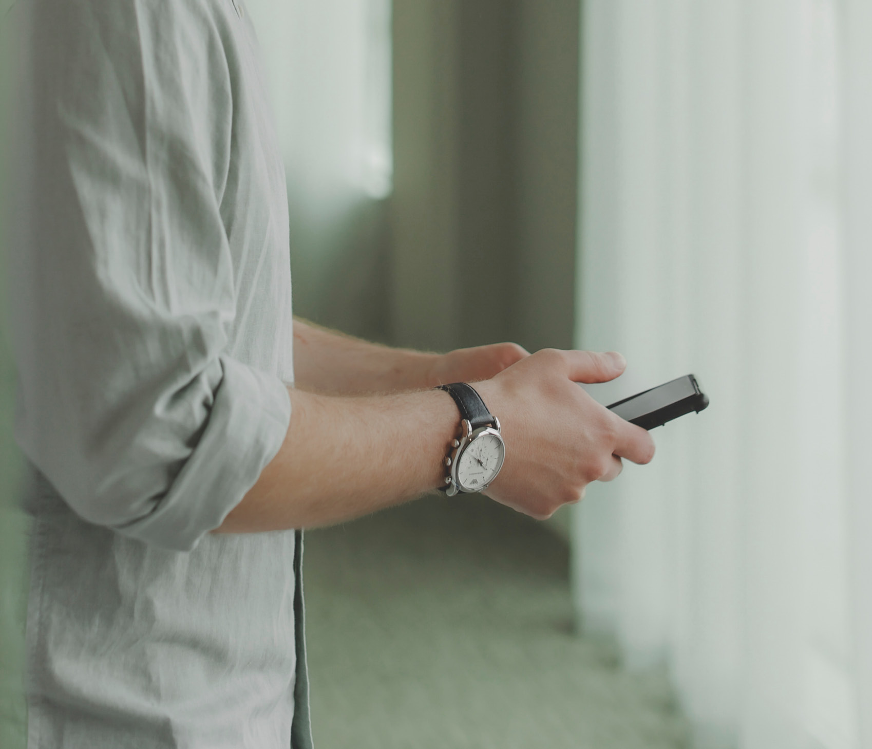 Man on phone looking at emails